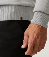 Sweater gris de tejido de punto con cuello redondo y mangas largas. Corte clásico.
