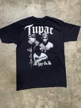 Remera negra de algodón con estampado frontal de la palabra "Tupac" en tipografía gótica blanca.