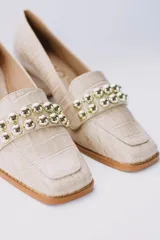 Zapato de cuero color beige con textura croco, taco cuadrado y detalle de apliques dorados.