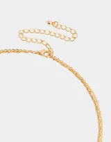 Collar corto doble dorado, con una cadena de eslabones y otra de eslabones retorcidos. La cadena más corta tiene circonitas engarzadas y la más larga tiene un dije circular con circonitas de colores.