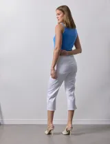 Pantalón capri color rosa de tencel elastizado con bolsillos simulados en la parte delantera y bolsillos aplicados en la parte trasera. Tiene pretina ancha, corte recto y terminación de ruedo desflecado.