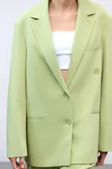 Blazer oversize color verde lima, con cuello solapa y mangas largas con hombreras. Tiene bolsillos delanteros y en el pecho, forro interior y cierre frontal multiposición.