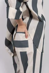 Pantalón recto de tiro medio con cintura elástica y corte holgado. Diseño a rayas verticales en tonos verde y blanco.