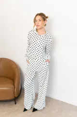 Camisa negra con estampado de lunares blancos, de manga larga y cuello clásico.
