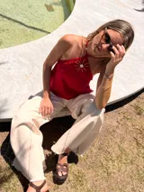 Musculosa color crema de lino y alpaca, con breteles finos que se atan al cuello y detalle de adorno de nácar en el centro del escote.