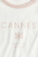 Remera blanca entallada corta en punto acanalado de algodón con estampado frontal "Cannes South of France" en color rosa.