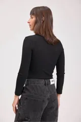 Blusa de punto canalé color verde azulado, de cuello alto y manga larga.