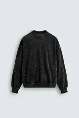 Sudadera negra de cuello redondo y manga larga con efecto lavado y acabados en rib.