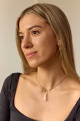 Collar dorado con cadena fina y dije colgante en forma de lágrima de piedra natural azul con vetas blancas.