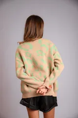 Sweater de punto color crudo con estampado animal print marrón.