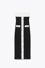 Vestido midi negro de tejido elástico, con escote recto y hombros descubiertos. Presenta falsos bolsillos con botón en el delantero, acabados a contraste en blanco y cierre frontal con botones.