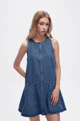 Vestido corto de denim azul, sin mangas, con cuello redondo y falda con volados.