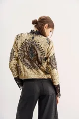 Saco corto dorado con lentejuelas y diseño de corazones.