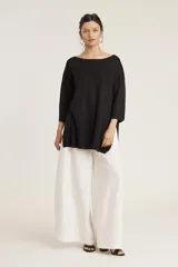 Conjunto de sweater y pantalón color beige con brillo metalizado. El sweater es holgado, de mangas 3/4 y cuello redondo. El pantalón es de corte palazzo.