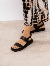 Sandalias de cuero negras con doble tira ancha y hebilla lateral.
