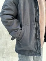 Campera negra con cierre frontal, cuello camisero y bolsillos laterales.