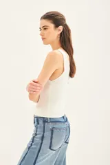 Musculosa blanca tejida en hilado de algodón, con escote en V pronunciado y calce al cuerpo.