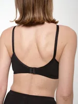 Soutien blanco de microfibra, sin aro ni relleno, con breteles regulables y detalle de costuras en el contorno de las copas.