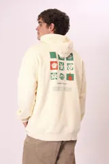 Sudadera con capucha de color verde oscuro (o verde petróleo) con efecto lavado, corte holgado y bolsillo canguro. Presenta un pequeño bordado blanco en el pecho con un diseño floral y texto.