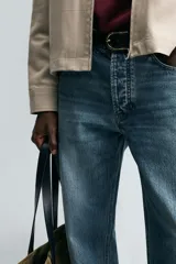 Pantalón de jean celeste de corte recto, con cinco bolsillos, efecto lavado y cierre frontal con botones.