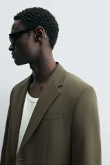Blazer slim fit color verde oliva confeccionada en tejido con viscosa. Cuello con solapas de muesca, manga larga acabada en puño con detalle de botones, bolsillo de vivo en pecho y de solapa en cadera. Detalle bolsillo interior, bajo con aberturas en espalda y cierre frontal con botones.