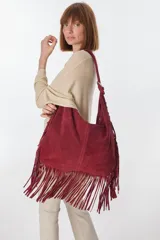 Bolso bandolera de gamuza color beige con flecos largos en la parte inferior.