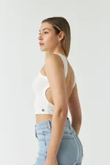 Top blanco sin mangas, con escote redondo y espalda descubierta.