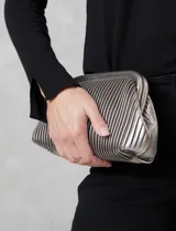 Cartera clutch color bordó, con diseño plisado vertical y asa de cadena metálica removible. Incluye bolsillo interior.