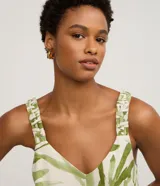 Musculosa femenina confeccionada en una mezcla de viscosa y lino, con estampado de follaje verde sobre fondo crudo. Presenta un cuello en V y breteles anchos con detalle fruncido, ofreciendo un calce regular y fluido.