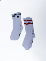 Pack de dos pares de medias deportivas blancas con rayas horizontales negras y rojas en la parte superior. Un par tiene la palabra "Mickey" en negro y el otro el logo de Disney.