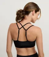 Top deportivo color tostado, confeccionado en microfibra con efecto satinado. Presenta copas y correas dobles ajustables.