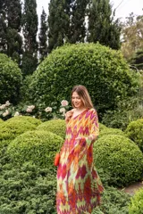 Vestido largo de gasa estampada, con forro, de un solo hombro y corte amplio. Estampado con colores naranja, violeta, verdes y detalles en amarillo.