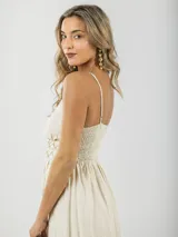 Vestido largo color crema, de breteles finos regulables, con guarda trenzada en la cintura y elástico en la espalda.