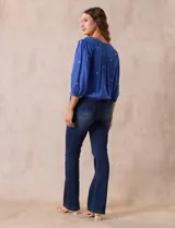 Blusa azul con bordados color crema, escote en V cruzado, mangas 3/4 abullonadas y nudo en el ruedo.