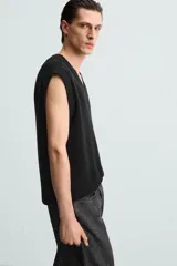 Chaleco negro de punto con cuello en V y sisas.