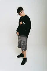 Bermuda de felpa gris oscuro con lavado gastado, corte ancho, estampado con serigrafía premium y bordado a un color.