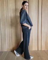 Conjunto de camisa y pantalón de lino blanco. La camisa es de manga larga y se ata en la parte delantera. El pantalón es de corte ancho y tiene cordón en la cintura.
