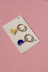 Aritos de vidrio hechos a mano con técnica murano, incluyen dijes intercambiables y argollas de acero inoxidable.