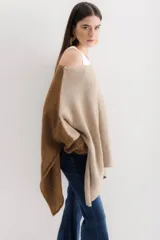 Poncho color beige de algodón tejido, con moldería oversize y tajos en los laterales.
