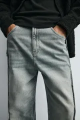 Pantalón de jean celeste de corte amplio con efecto lavado. Tiene cinco bolsillos y costuras frontales en las piernas.