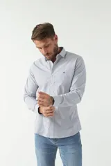 Camisa celeste a cuadros, de corte slim fit, manga larga y logo bordado. Confeccionada en 100% algodón.