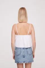 Musculosa blanca de breteles finos con detalles de encaje en el escote y bordado calado en el cuerpo.