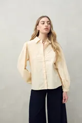 Camisa blanca de mangas 3/4 abullonadas con bordado floral en el frente.