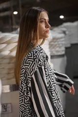Camisa holgada estampada en blanco y negro con diseño geométrico y mangas con rayas verticales.