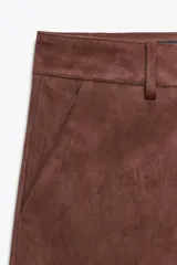 Bermuda marrón de tiro alto con trabillas, bolsillos laterales y cierre frontal con cremallera, botón interior y ganchos metálicos.
