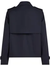 Gabardina corta azul marino de Tommy Hilfiger, con botonadura simple, cuello inglés, trabillas en los hombros, solapa de protección delantera y trasera, puños con tira y botón, y logo metálico en el puño.