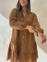 Vestido corto marrón de pana con cuello mao, manga larga abullonada con puño elástico, corte evasé y botones frontales.
