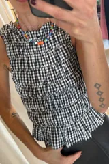 Top corto con estampado vichy en rojo y blanco, con breteles finos y detalle de fruncido en el escote.