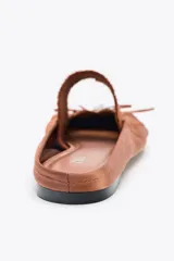 Zapato plano destalonado color marrón, con efecto satinado, detalle de fruncidos en la punta, lazo con perla en la parte delantera, tira elástica en el empeine y acabado en punta redonda.