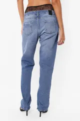 Pantalón denim azul de tiro bajo y pierna angosta. Cierre metálico con botón personalizado, cinco presillas, plastisol de marca en espalda y bolsillos laterales con relojero y remaches. Lavado azul con bigotes láser artesanales.